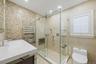 Bathroom with tile walls, vanity, a stall shower, recessed lighting, and light tile patterned flooring