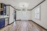 Unfurnished dining area featuring a chandelier, ornamental molding, light wood-style flooring, and radiator
