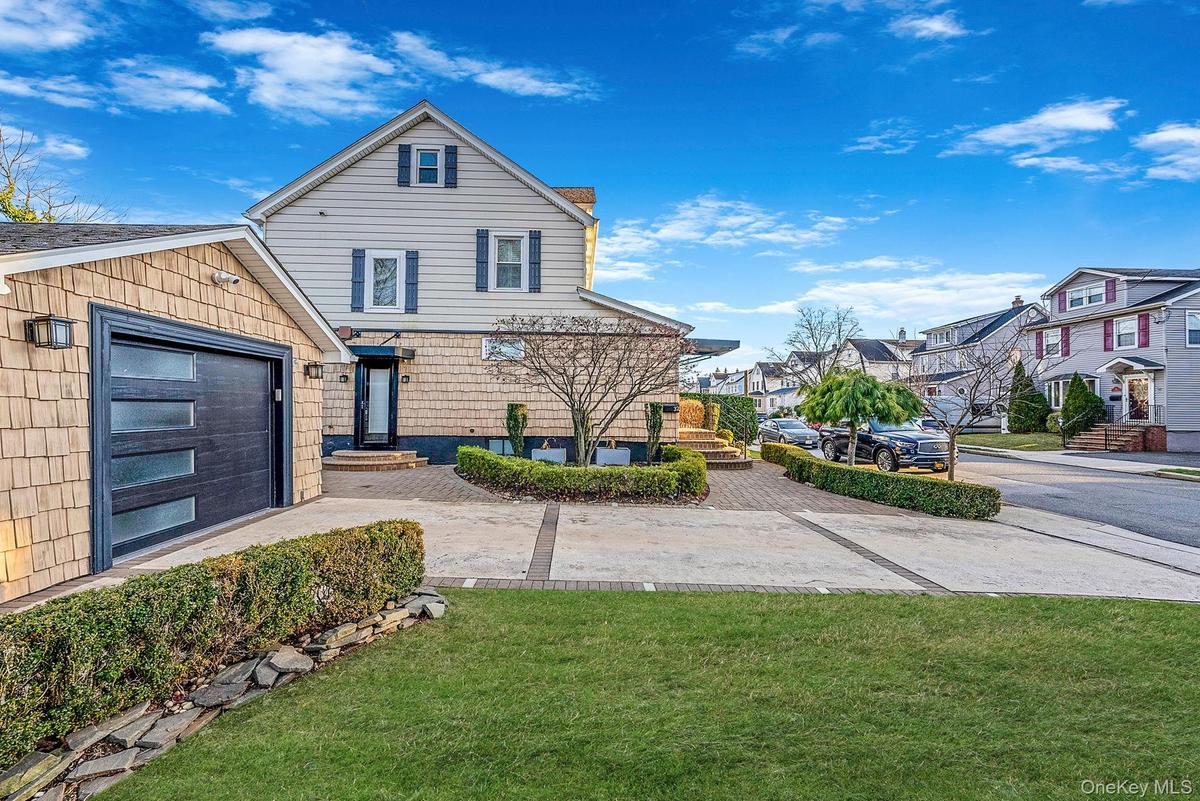 View of front of house featuring a front yard, a garage, and a residential view