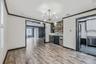 Kitchen with ornamental molding, stainless steel appliances, backsplash, glass insert cabinets, and light wood-style flooring