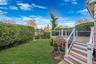 View of grassy yard featuring a deck and stairway