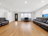 Spacious room featuring wood-finish flooring, recessed lighting, and a dark wood entry door with vertical glass insert