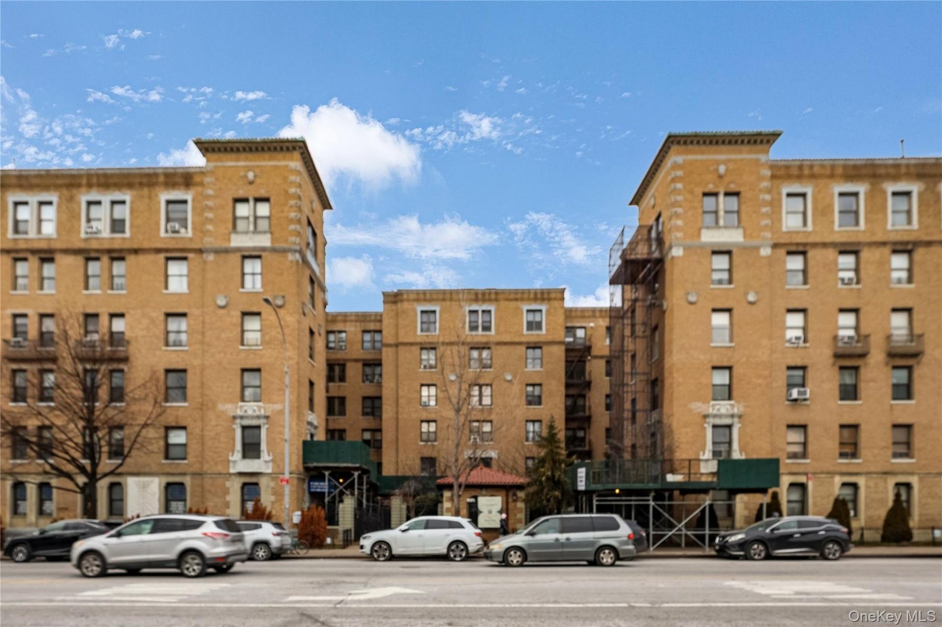 Multi-story brick facade building featuring a central entrance with a green awning