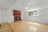 Lower level family room with traditional wood burning fireplace.