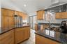 Kitchen with stainless appliances, gas stove, granite counters and sliding glass door to deck.