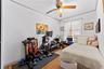 Bedroom 2 - Featuring wood-finish flooring, white walls, and a ceiling fan with integrated lighting