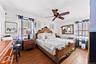 Bedroom 1 - Hardwood flooring, ceiling fan with light fixture, multiple windows with blinds, and white walls