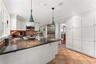 Dine-In Kitchen featuring stainless steel appliances, granite countertops, two sinks, custom cabinetry and access to the yard via  the French Door.