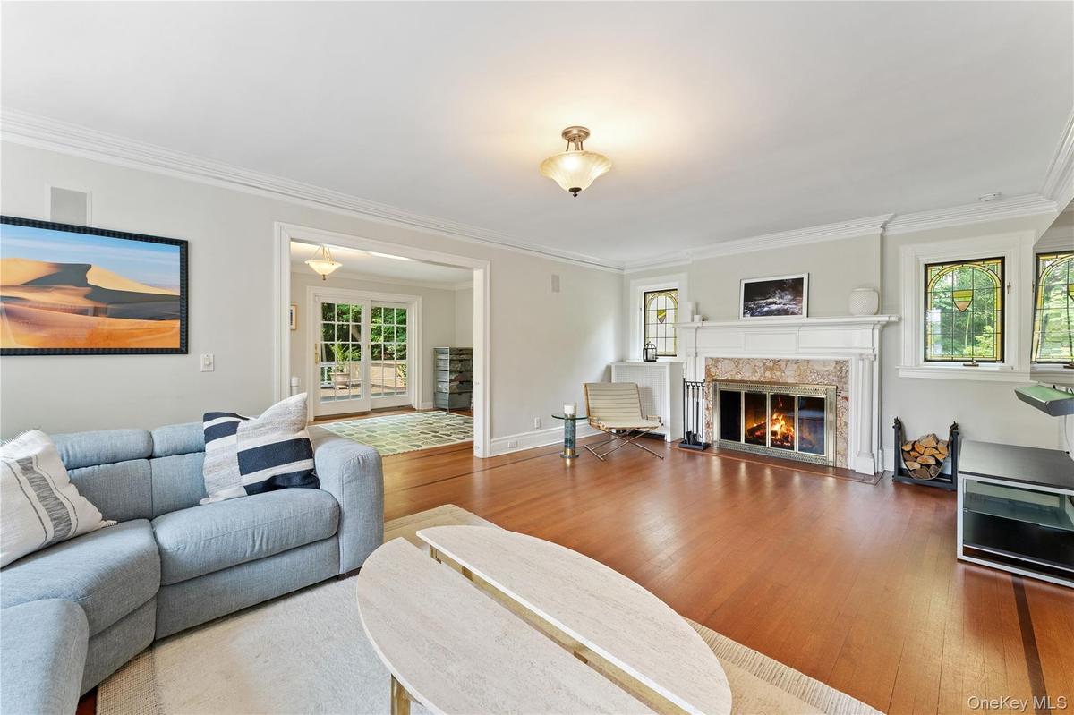 Living Room view featuring wood-burning fireplace and hardwood floors.