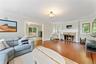 Living Room view featuring wood-burning fireplace and hardwood floors.