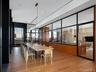 Spacious interior with wood-finish flooring, a contemporary linear chandelier, and floor-to-ceiling windows