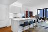 Contemporary kitchen featuring  custom Italian white lacquer cabinetry, Calacatta Lincoln marble countertops, natural stone finishes, and a full suite