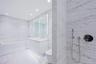Primary Bathroom Spa-inspired bathrooms feature Blue de Savoie stone floors, Calacatta Lincoln marble walls, oversized walk-in showers, and meticulous