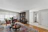 Hardwood flooring extends throughout the living area, complemented by a large window with roller shades