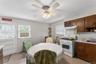 Eat-in kitchen featuring wood cabinetry, a white gas range with overhead ventilation, and a white subway tile backsplash