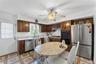 Kitchen featuring wood cabinetry, white subway tile backsplash, and light-toned countertops