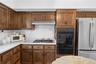 Kitchen featuring extensive wood cabinetry, white subway tile backsplash, white countertops, built-in gas range, and double wall ovens