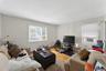 Living area featuring wood-finish flooring, light neutral wall paint, and white trim