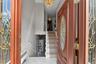 Entry foyer with tiled flooring and a multi-level staircase featuring white risers and handrails