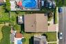 Brown shingle roof with a rear elevated patio, accompanied by a front paver driveway and mature landscaping