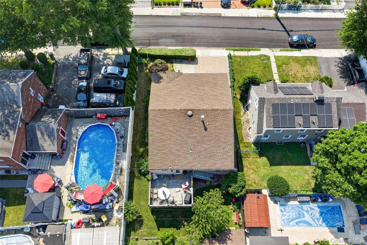 Expansive residential property featuring a large backyard patio, a well-maintained lawn, and mature trees