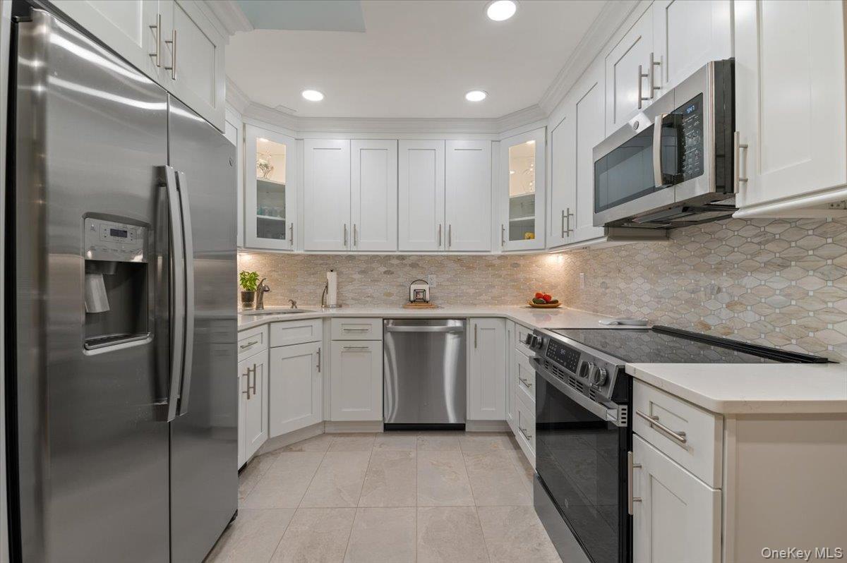 Brand New Top of the Line Stainless Steel Appliances are accented with Mosaic Ceramic Backsplash and Quartz Countertops with Plenty of Room for Meal P