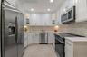 Brand New Top of the Line Stainless Steel Appliances are accented with Mosaic Ceramic Backsplash and Quartz Countertops with Plenty of Room for Meal P