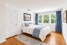 Second floor bedroom with abundant light and backyard garden views.