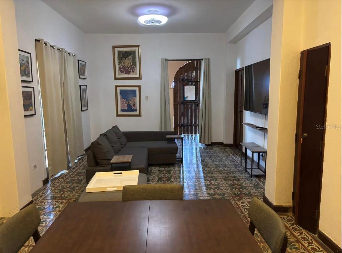 1st floor living/dining/family/great room looking to front door with furniture prior to renovation of floor tiles.