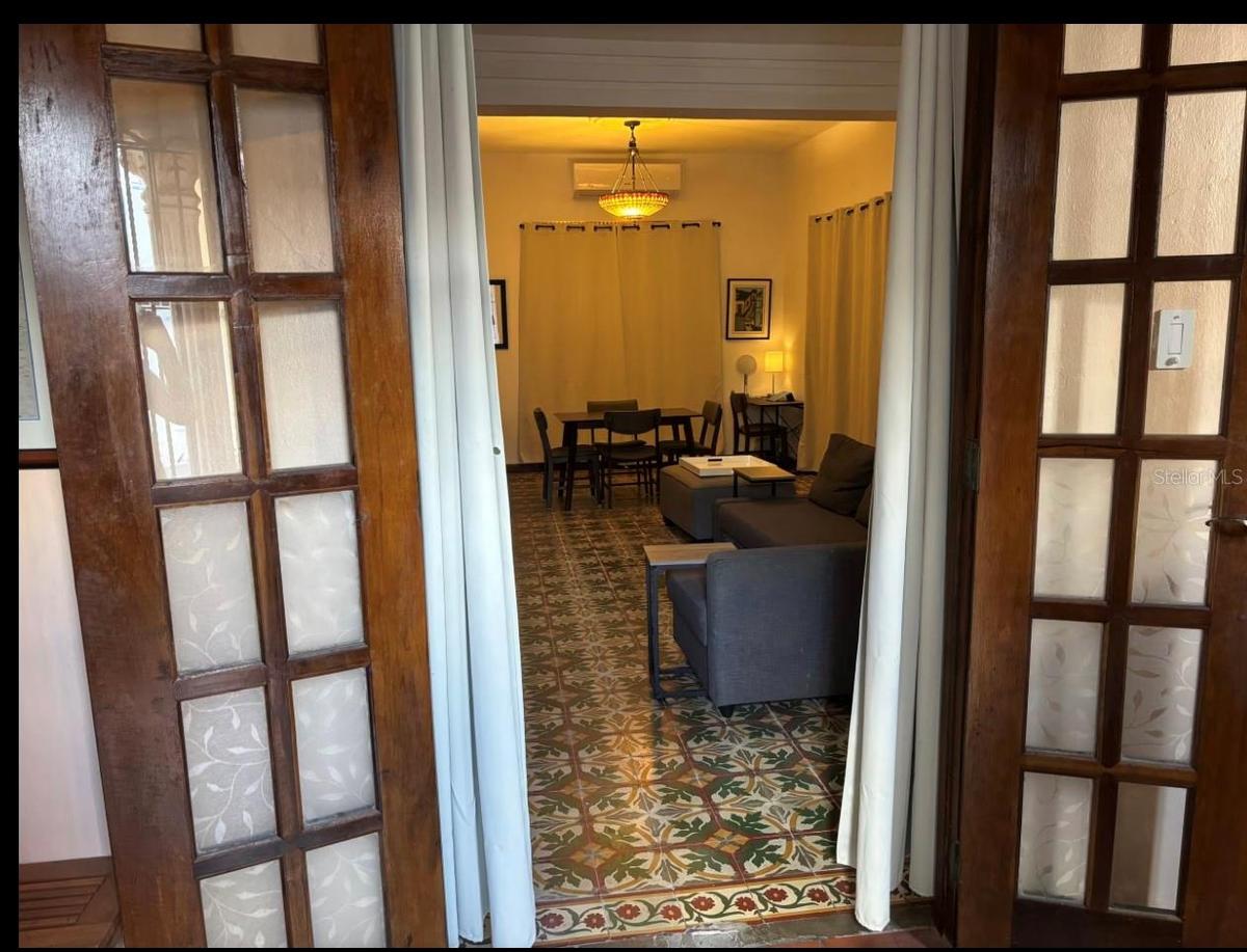 1st floor living/family/greatroom with furniture prior to renovation of floor tiles. French doors on 3 sides allow a very open experience.