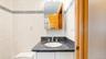 Bathroom vanity featuring a dark speckled countertop with an undermount sink and chrome faucet