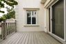 Outdoor deck featuring composite decking, a wooden railing, a sliding glass door, and an exterior window with decorative molding