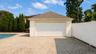 Detached garage structure featuring a white paneled garage door, stucco exterior, and a shingled roof