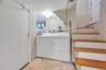 Dedicated laundry area featuring a white top-loading washing machine and a white front-loading dryer, set on tiled flooring