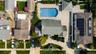 Expansive property featuring a curved inground pool, an extensive paved patio, and mature landscaping