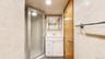 White vanity with a laminate countertop, chrome faucet, and mirrored medicine cabinet