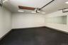 Spacious garage featuring textured black flooring, white painted walls, recessed lighting fixtures, and an automatic garage door opener mechanism