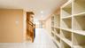 Storage area featuring extensive built-in shelving, recessed lighting, and tile flooring