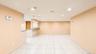 Spacious open-concept area featuring light-toned tile flooring, recessed ceiling lighting, and a neutral wall palette