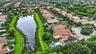 Aerial view showcasing a residential property with solar panels and a private pool, positioned along a water feature