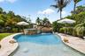 Resort-style pool featuring a rock waterfall and integrated spa