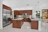 Expansive kitchen featuring wood cabinetry, stainless steel appliances, a center island with countertop seating, and recessed lighting