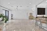Expansive living area featuring large format tile flooring and a wet bar with dark cabinetry and a granite-style countertop