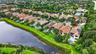 Aerial perspective of a private residence featuring a tile roof, solar panels, and a backyard swimming pool