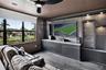 Custom built-in media console with stone-finish accent wall, integrated display shelving, and recessed lighting