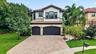 Mediterranean-style residence featuring a tile roof, stucco exterior, and arched entryway detailing