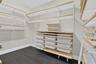 Customizable closet system featuring wood-finish shelving, integrated drawers, hanging rods, and dark wood-finish flooring