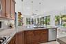 Spacious kitchen featuring a large island with dual sinks, wood-finish cabinetry, and light-toned countertops