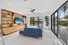 Bright living area featuring a custom built-in entertainment center with integrated lighting, wood-finish shelving, and cabinetry