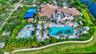 Expansive community clubhouse featuring a large swimming pool, recreational basketball court, and dedicated children's splash pad